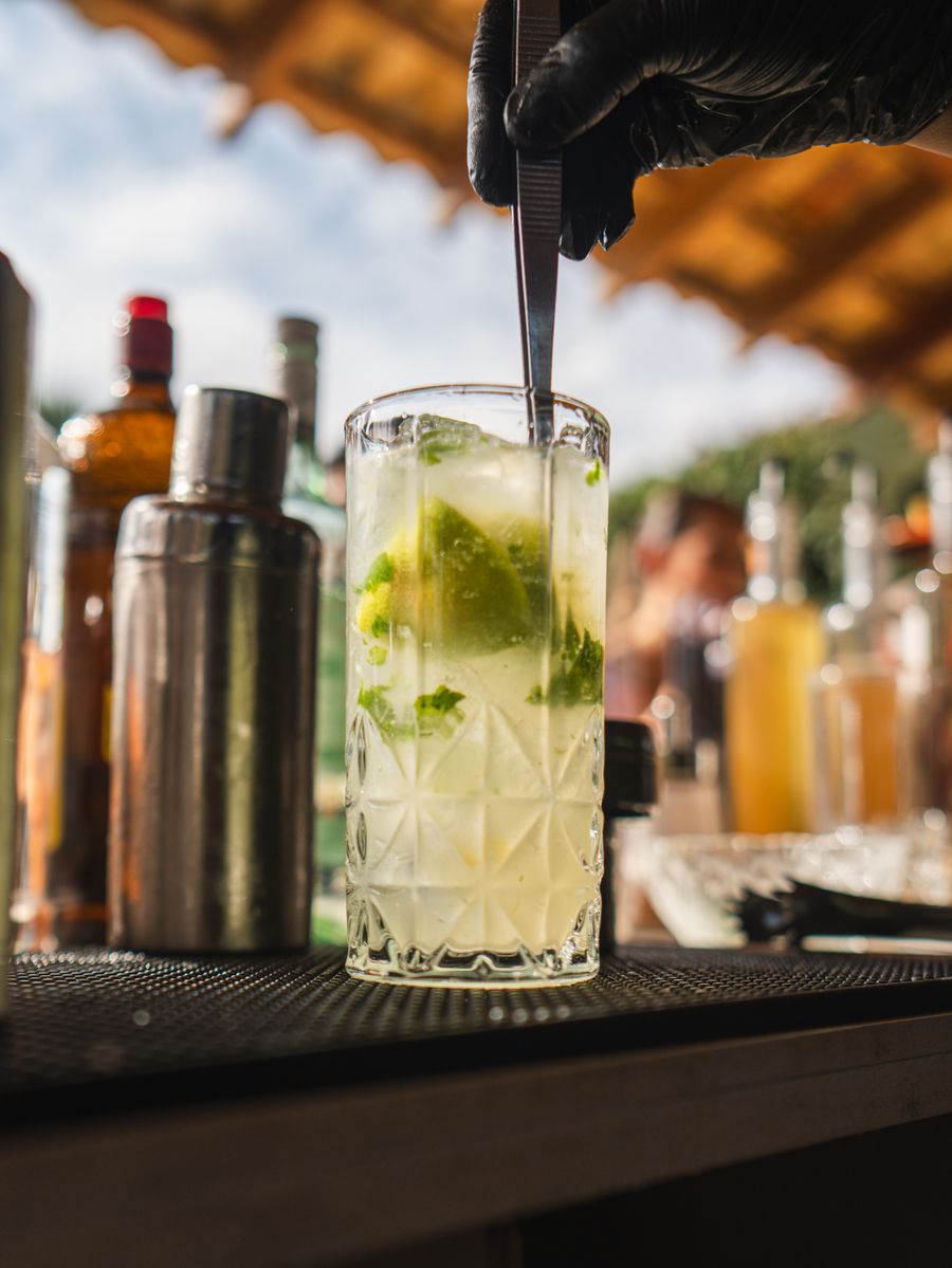 Caipirinha ilustrativa com limão, gelo e hortelã